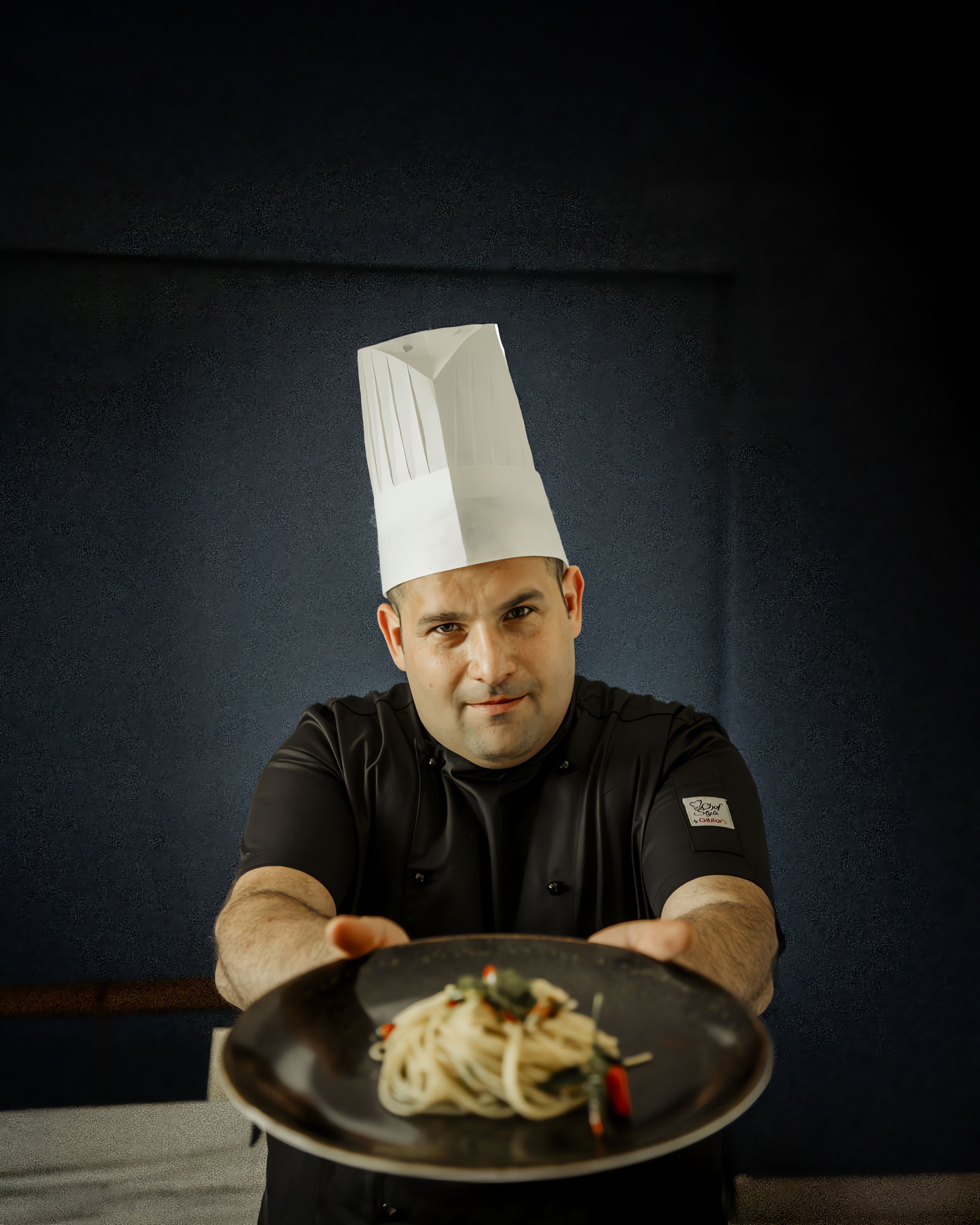 Chef Dario Ciulla presenting a plate of spaghetti